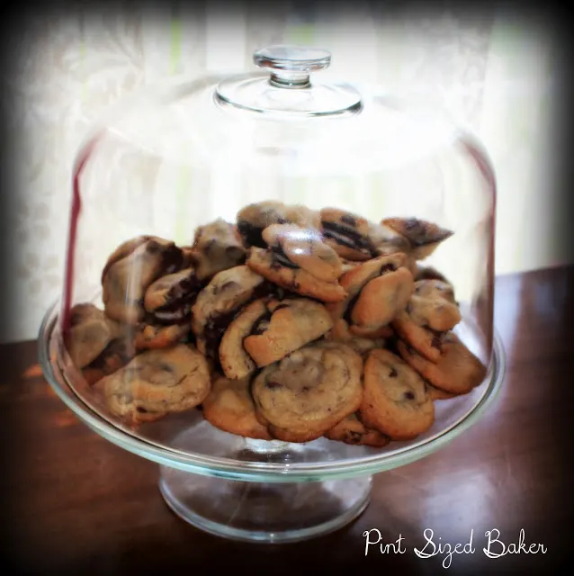 A photo of the cookies on a cake platter with a glass dome.