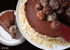 A perfect cake -Combed chocolate frosting with macadamia nuts around the perimeter and topped with truffles.