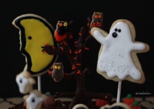 Cookie Ghosts and a chocolate "tree" with spooky owls decorate a Halloween Graveyard Cake.