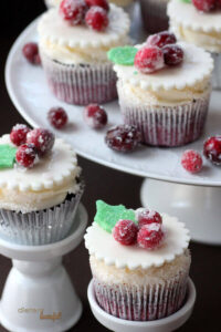 Sugared cranberries sparkle and shine on top of these beautiful red velvet cupcakes.