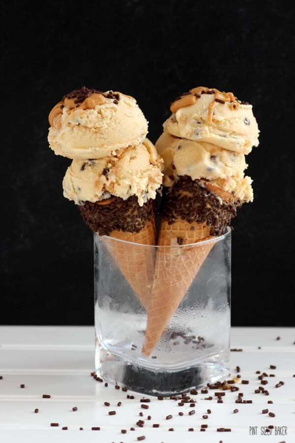 Two peanut butter dipped ice cream cones with chocolate sprinkles filled a double scoop of peanut butter ice cream.