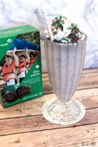 A box of Girl Scout Thin Mints sit behind the milkshake made with the cookies.