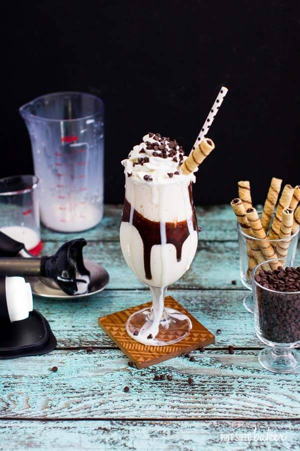 A photo of the Vanilla Milkshake with chocolate swirls with all of the toppings and accessories to make it.