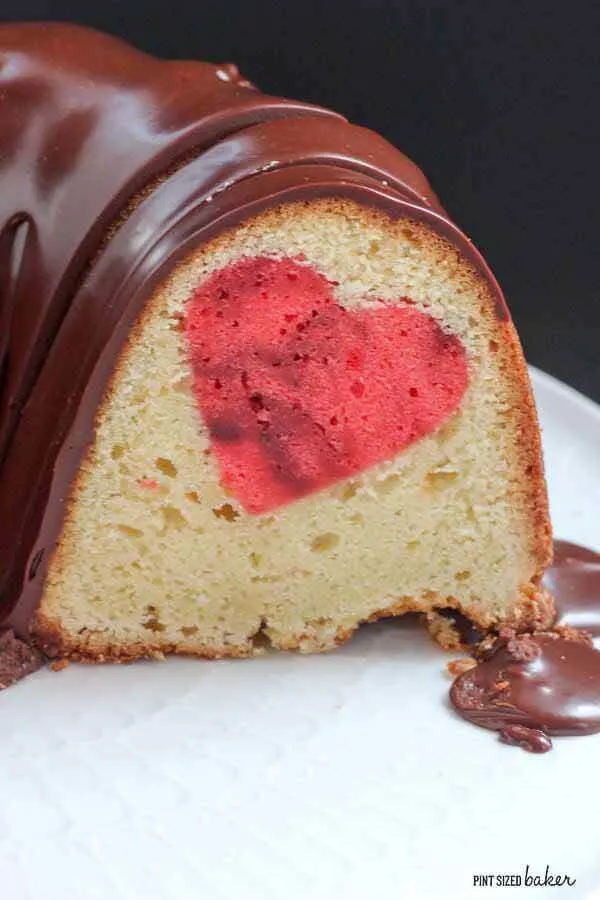Close up image of the pound cake with the heart inside and ganache drizzle on top.