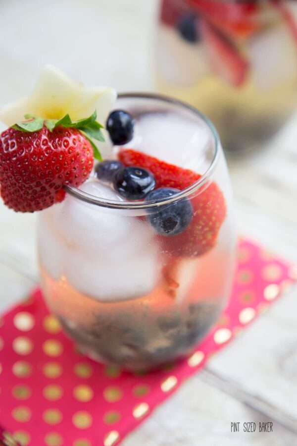 Bottoms up! This fun Summer Sangria recipe. Full of strawberries, blueberries, and apples, this red, white, and blue sangria recipe serves a crowd!