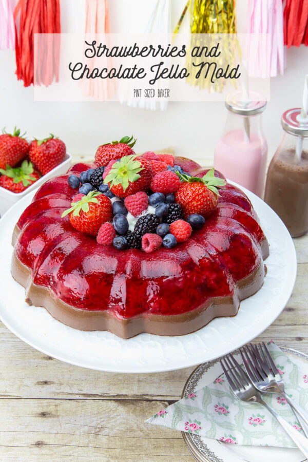 A Strawberry and Chocolate Jell-o mold made in a bundt pan with the center filled with whipped cream and gresh berries.