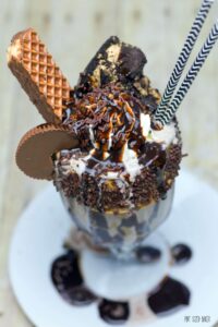 A decadent Chocolate and Peanut Butter Monster Milkshake loaded with fresh whipped cream, a Reese's cup, a Little Debby Nutty Bar, and a slice of Peanut butter pie! OMG it was amazing!