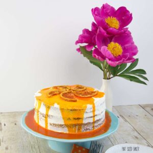 A beautiful Orange Olive Oil Cake with whipped cream frosting and candied Cara Cara Orange slices on top.