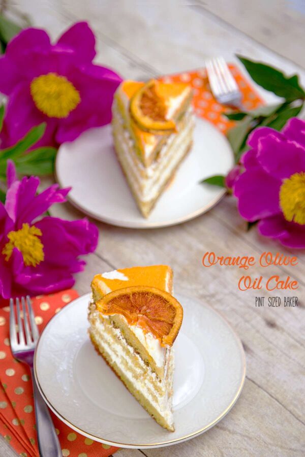 Light and fluffy layers of Orange Olive Oil Cake recipe with whipped cream frosting and a candied orange slice on top.