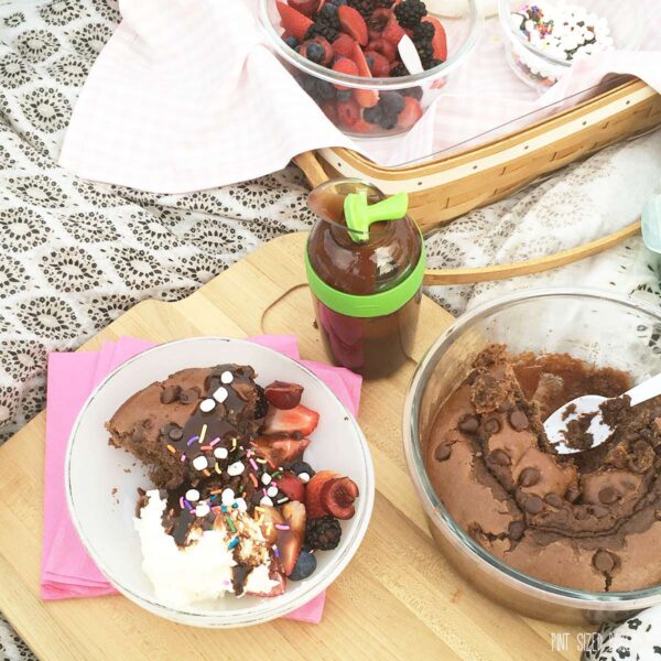 Picnic Chocolate Cake with fresh fruit, whipped cream and chocolate sauce all served at the park.