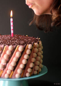 A Strawberry Birthday cake like no other! A delicious six layer cake with strawberry curd and covered in strawberry Whoppers and Pocky Sticks.