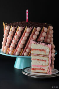 Count up six layers of white cake with layers of strawberry curd and Swiss Meringue Buttercream and then decorated with strawberry Whoppers and Pocky Sticks.