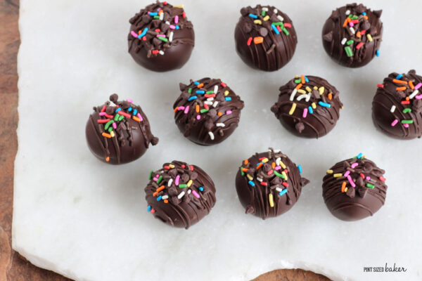 Cake truffles with rainbow sprinkles on a serving platter. 