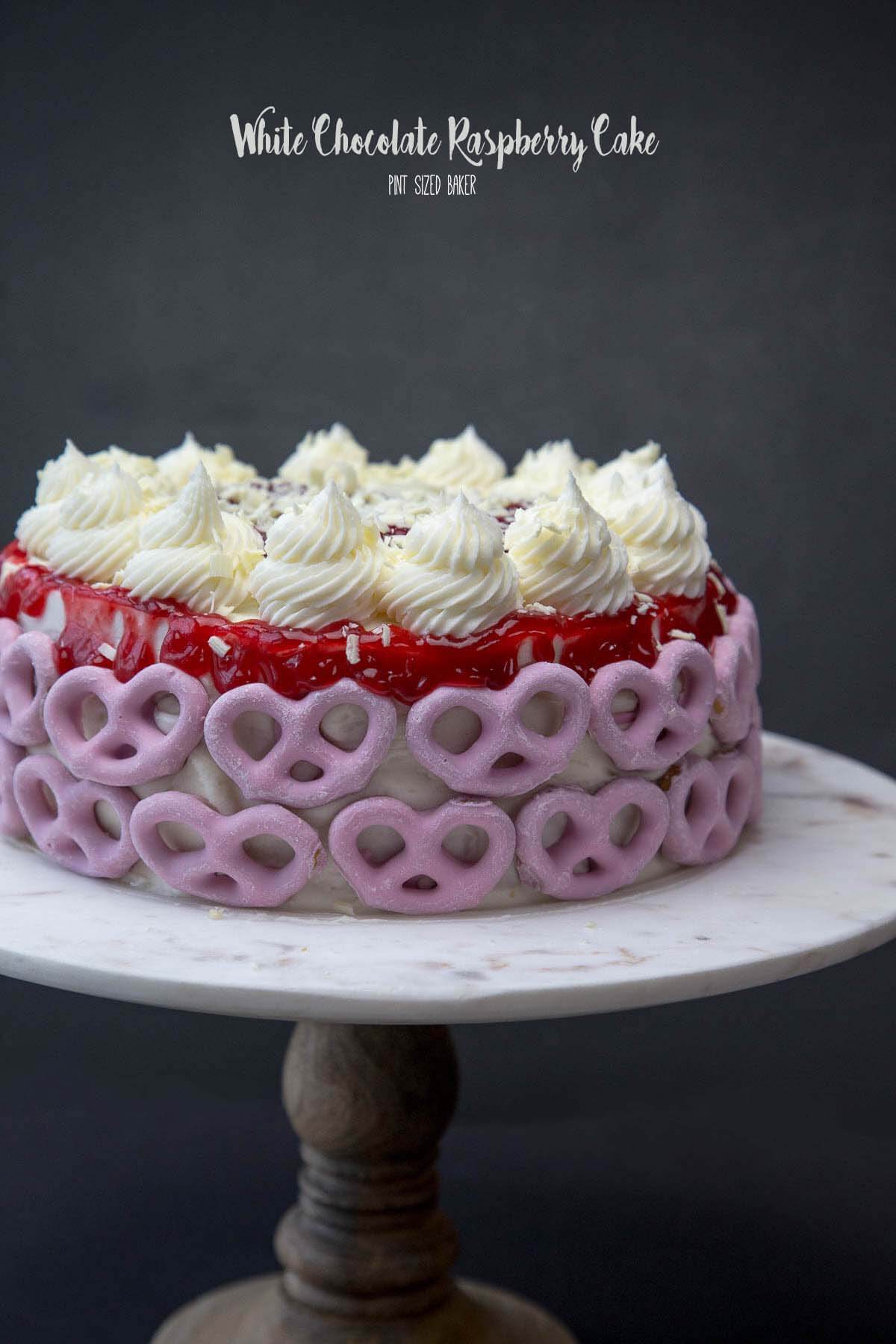 Everyone is going to want a slice of this White Chocolate Raspberry Cake decorated with sweet and salty raspberry pretzels.