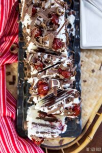 Slice into this No Bake Eclair Cake and you'll find layers and layers of chocolate graham crackers, white chocolate pudding and cherries! It's the ultimate no bake dessert!