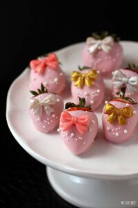 Pink Chocolate Covered Strawberries with pretty bows on. All dressed up for a thrilling New Years Eve or a fun Great Gatsby Party.