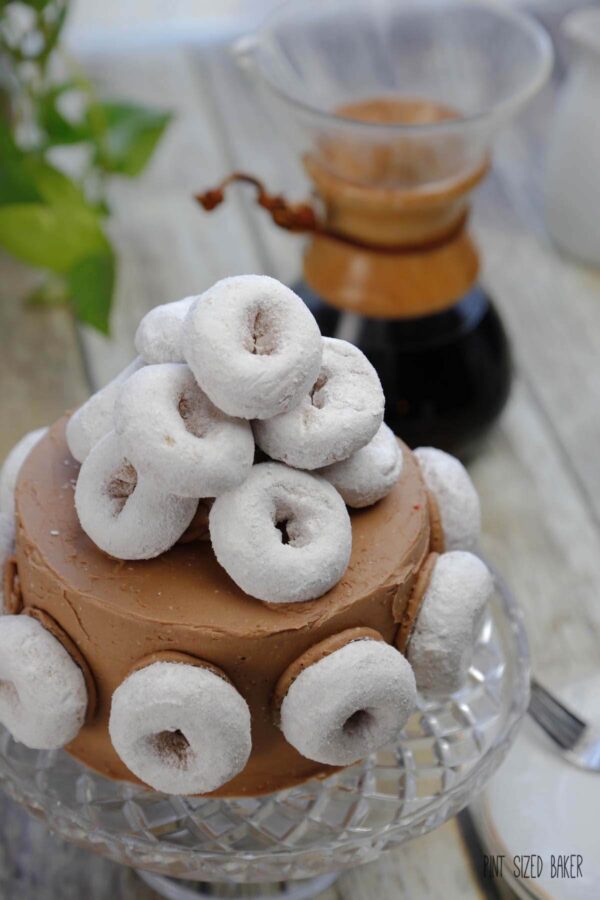 This Coffee and Donuts Cake is Homer Simpson approved! It's loaded with coffee flavor and covered with powdered sugar doughnuts. Yum!