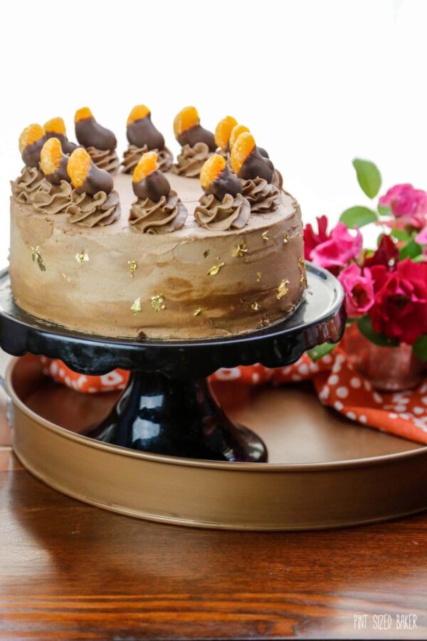 An image of the cake with vegan buttercream and chocolate dipped clementine slices.