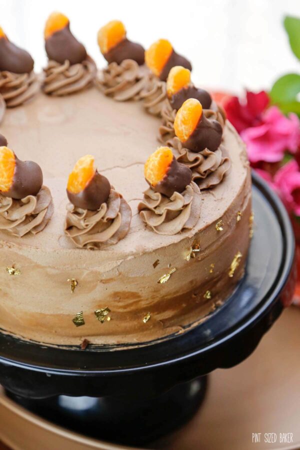 A top image of the cake showing off the buttercream swirls and the chocolate dipped clementine segments.