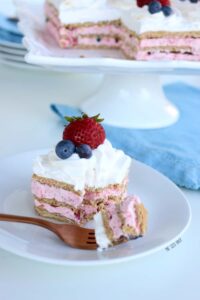 A serving of Icebox Cake with fresh strawberries and blueberries.