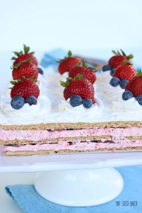 Icebox Cake Recipe with fresh strawberries and blueberries on a pedestal stand.