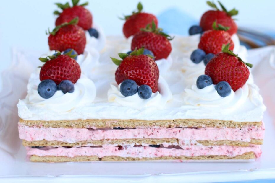 Icebox Cake Recipe with fresh strawberries and blueberries on a pedestal stand.
