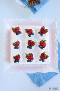 Overhead view of an Icebox Cake Recipe with fresh strawberries and blueberries on a pedestal stand.