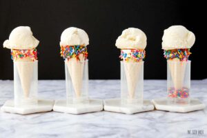 four vanilla ice cream cones lined up in a row