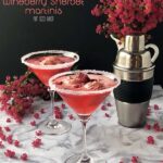 Wineberry Sorbet Martinis on a table with pink flowers.