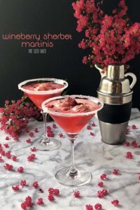 Wineberry Sorbet Martinis on a table with pink flowers.