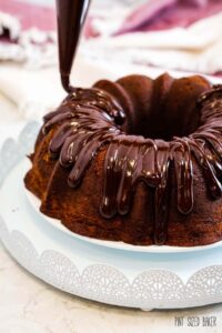 A photo of the chocolate ganache being drizzled over a chocolate bundt cake