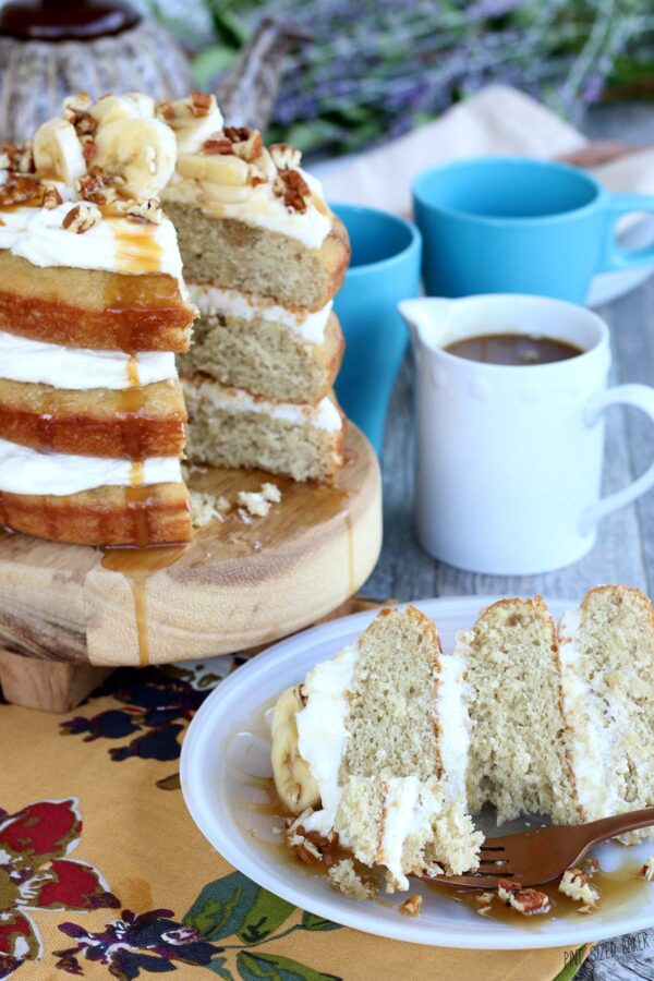 Finished naked cake is sliced and on a plate ready to be eaten. Lovely layer cake showing the filling between layers. 