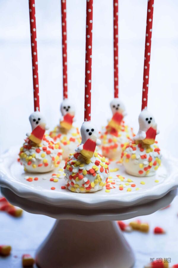 BOO! An image with the cake pops with orange straws and candy ghosts as decoration.