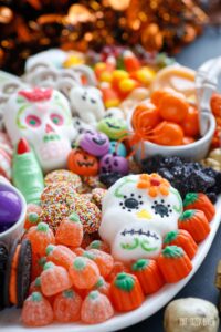 Sugar skull marshmallow and candy pumpkins on a Halloween platter.