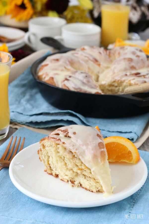 A slice of breakfast bread on a plate with an orange slice. Orange bread twist goes great with other breakfast favorites.