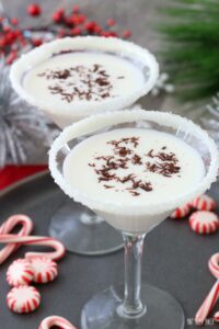 A christmas themed white chocolate martini with decorations on the tray and a sugared rim on the glass!