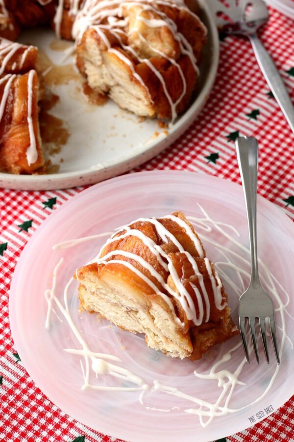 Here we see the Pillsbury monkey bread finished and topped with icing, it's sliced and on a plate ready to be eaten.