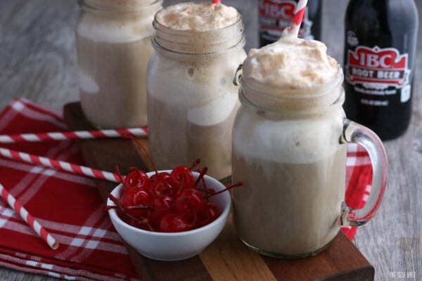 Vue horizontale des flotteurs de root beer à la vodka et à la crème glacée terminés, avec les ingrédients en arrière-plan pour en faire plus !