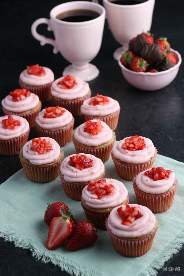 A close up image of cupcakes with real strawberry frosting and diced fresh strawberries on top.
