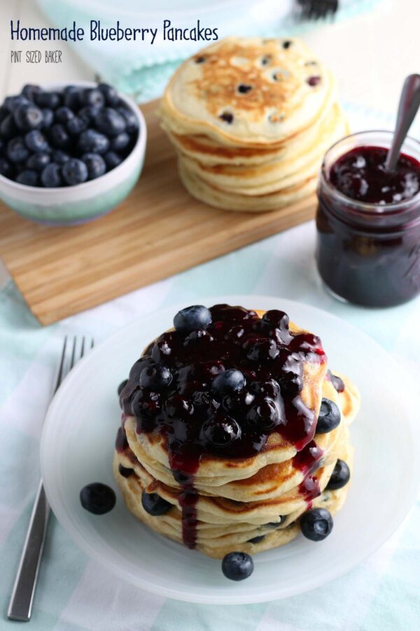 A giant stack of Fresh Blueberry Pancakes covered with blueberry sauce.