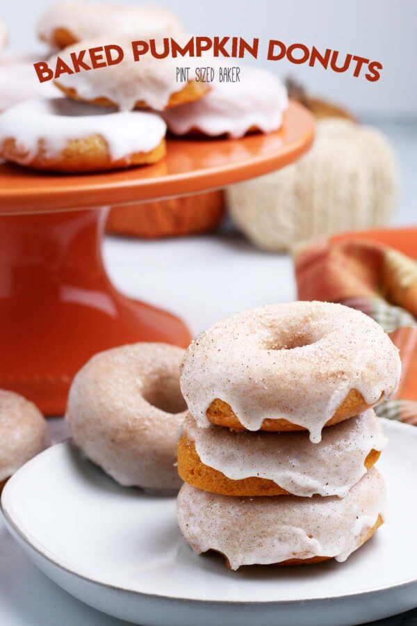 A plate piled high with three Baked Pumpkin Donuts with cinnamon sugar glaze.