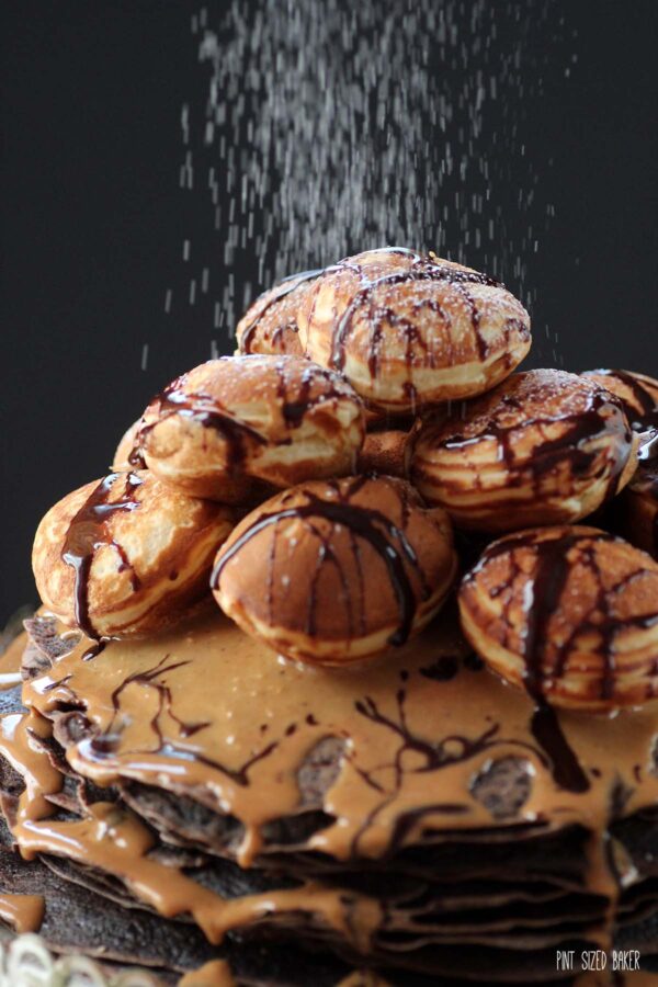 A photo showing the powdered sugar being sprinkled over the chocolate and peanut butter crepes. 
