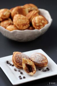 An image showing the inside of the Aebleskiver stuffed with a mini chocolate peanut butter cup.