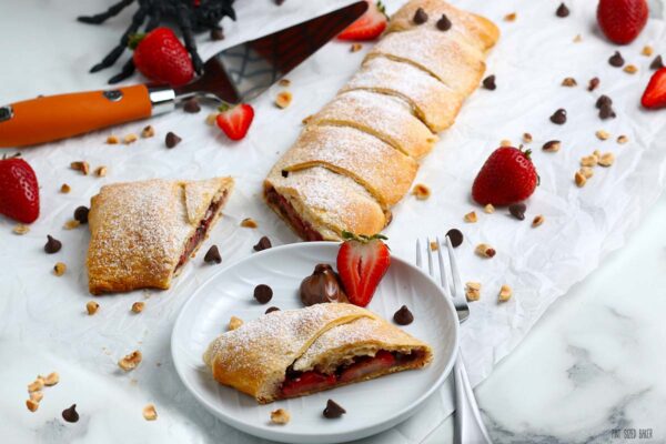 A horizontal image of the pastry wrap with sliced strawberries, chocolate chips, and hazelnut pieces. 