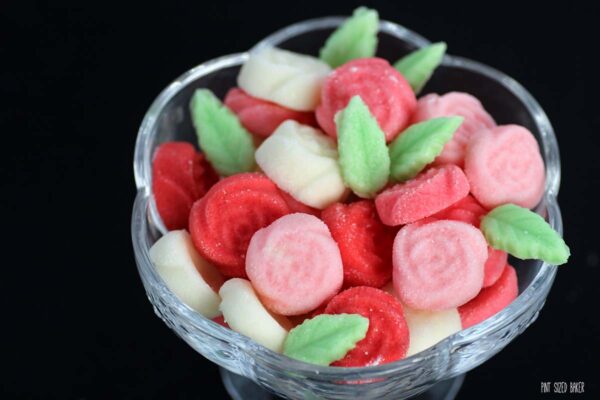 Little rose cream cheese candies in a glass serving bowl. 