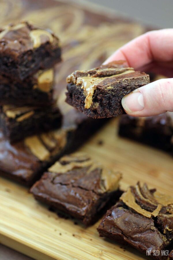 A side view of the brownie slice to show off the dense, gooey center of the brownies along with the crispy baked top.