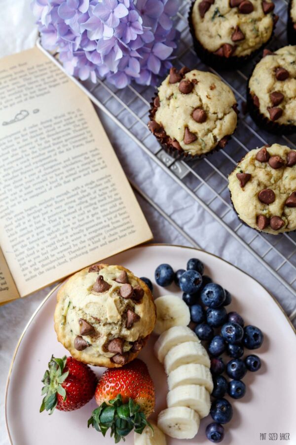 A cozy breakfast setting with warm banana muffins, fresh fruit, and a good book.