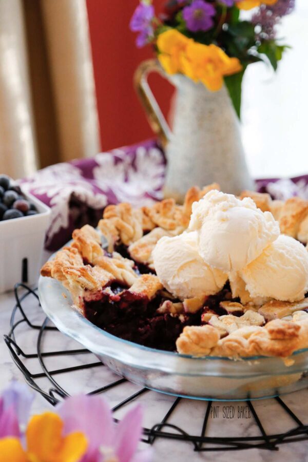 Blueberry Pie with three scoops of vanilla ice cream on top. 