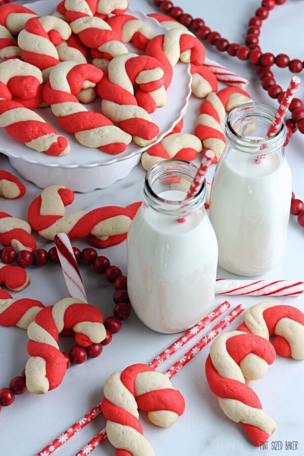 Cookies and milk with candy canes and red straws all laid out for Santa.