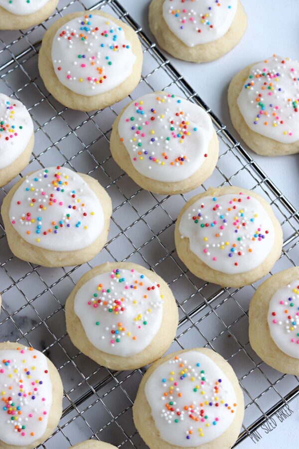 Cookies on a cooling rack with rainbow sprinkles.